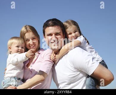 Felice giovane famiglia con due bambini all'aperto Foto Stock