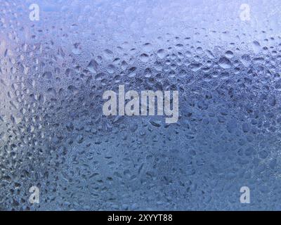 Gocce di acqua e ghiaccio sul vetro del finestrino Foto Stock