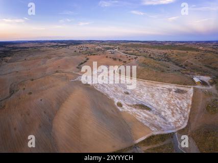 Panorama aereo di un paesaggio collinare simile a un deserto con polvere di pietre di marmo al tramonto a Terena, Portogallo, Europa Foto Stock