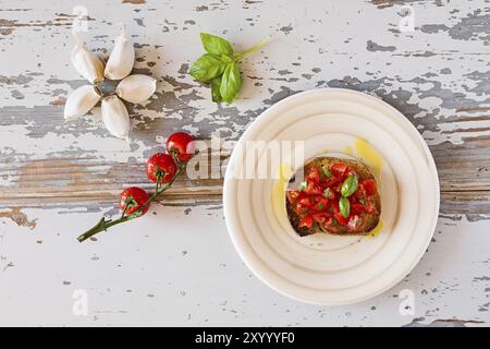 Italian bruschetta con pomodoro e basilico visto da sopra un vecchio tavolo Foto Stock