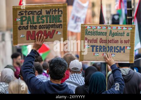 Manchester, Regno Unito. 31 agosto 2024. Cartelli pro-palestinesi. Manifestanti palestinesi a Manchester nel loro 48esimo fine settimana di protesta dopo l'attacco di Hamas il 7 ottobre. I manifestanti marciarono attraverso il centro di Manchester iniziando e finendo in Piazza San Pietro. La marcia si fermò all'edificio assicurativo di Axa, in King Street, per ringraziare la compagnia per il disinvestimento in Israele. Autobus e tram furono trattenuti mentre la marcia procedeva con una scorta della polizia. Manchester Regno Unito. Immagini garyroberts/Worldwide Features. Crediti: GaryRobertsphotography/Alamy Live News Foto Stock