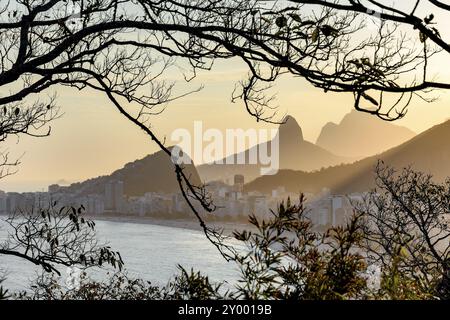 Spiaggia di Copacabana a Rio de Janeiro durante il tramonto tra la vegetazione sulla collina Foto Stock