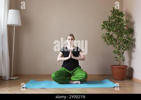 Persone di mezza età o donna matura fare yoga in ambienti interni Foto Stock