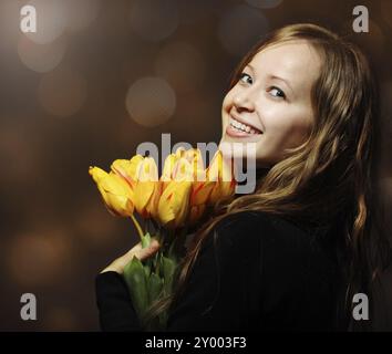 Donna bionda felice con bouquet di tulipani arancioni Foto Stock