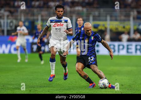 (R-L) Federico Dimarco dell'FC Internazionale e Ederson Jose dos Santos Lourenco da Silva dell'Atalanta BC visto in azione durante la partita di calcio di serie A 2024/25 tra FC Internazionale e Atalanta BC allo Stadio Giuseppe Meazza. Punteggio finale; Inter 4:0 Atalanta. Foto Stock