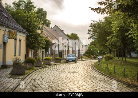 BERLINO, GERMANIA, 16 LUGLIO 2013: Strada di ciottoli a Marzahn con auto parcheggiata e case il 16 luglio a Berlino, Germania, Europa Foto Stock