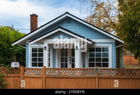 Casa di campagna in Nord America. Casa di legno nella foresta verde. casa o cottage in legno con recinzione in legno e alberi intorno. Casa in stile country. Esterno Foto Stock