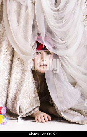 La bambina gioca a nascondino in un costume da pirata Foto Stock