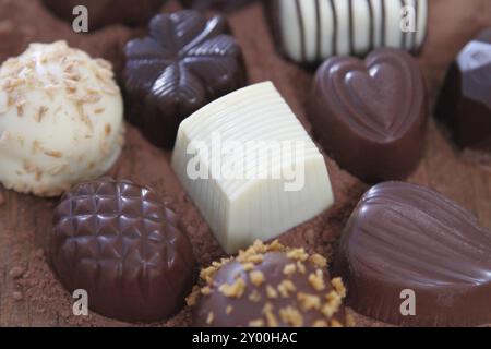 Vari tipi di praline isolato su sfondo di cioccolato Foto Stock