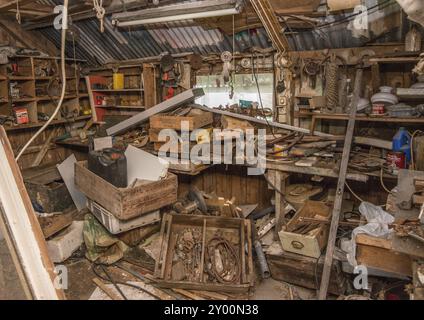 Ramsland, Norvegia, 9 settembre 2016: Banco da lavoro vecchio e disordinato con vecchi utensili. In una capanna, l'Europa Foto Stock