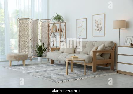 Elegante soggiorno con schermo pieghevole e divano. Design degli interni Foto Stock