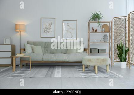 Elegante soggiorno con schermo pieghevole e divano. Design degli interni Foto Stock