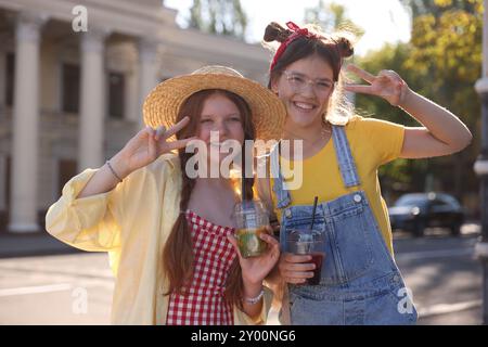 Amici adolescenti felici che mostrano segnali di pace sulla strada della città Foto Stock