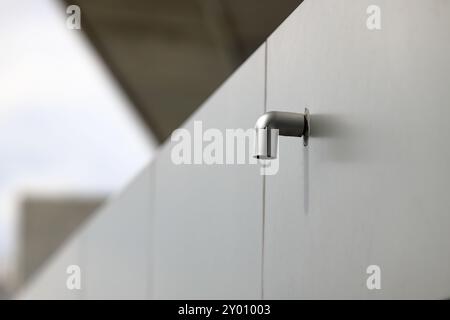 Tubo di scarico o canaletta in PVC del tetto, tubo discendente dell'acqua piovana. Sistema di drenaggio della casa in un edificio moderno. Foto Stock