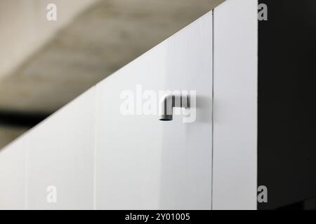 Tubo di scarico o canaletta in PVC del tetto, tubo discendente dell'acqua piovana. Sistema di drenaggio della casa in un edificio moderno. Foto Stock