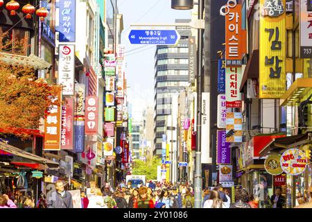 Seoul, Corea del Sud, 17 aprile 2015: Persone che camminano lungo la vivace strada pedonale dello shopping di Myeongdong circondata da negozi commerciali, segnalano AN Foto Stock