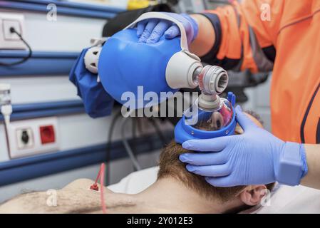 Covid-19 insufficienza respiratoria. Medico d'urgenza usando maschera Ambu sacco su un paziente con polmonite a causa di infezione da Coronavirus, per ventilazione artificiale Foto Stock