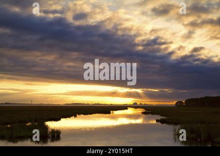 Raggi di sole caldi attraverso il cielo nuvoloso sul lago Foto Stock