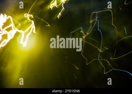 Sequenze di luce dinamiche nelle tonalità verde e giallo su sfondo scuro Foto Stock