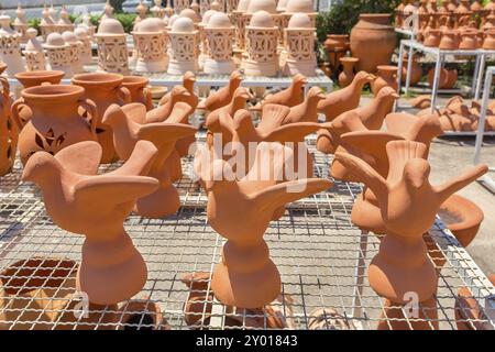 Gruppo di uccelli arancioni di argilla all'esterno presso il negozio di ceramiche Foto Stock