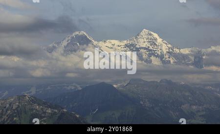 Montagne innevate Eiger e monch in una nuvolosa giornata estiva Foto Stock