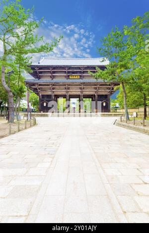 Ampio sentiero che conduce alla grande porta sud, nandaimon, con nessuno presente al complesso del tempio Todai-ji in una bella giornata estiva di cielo azzurro e soleggiato a Nara Foto Stock