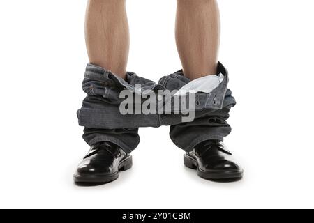 Beccato con i pantaloni giù, uomo con scarpe nere e jeans caduti in piedi sul pavimento Foto Stock