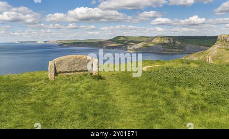 Banco di pietra a lungo la costa sud occidentale percorso con una veduta della Jurassic Coast e Emmett's Hill, vicino Worth Matravers, Jurassic Coast, Dorset, Regno Unito Foto Stock