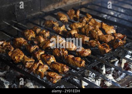 Grigliare lo shashlik marinato per prepararsi su un barbecue con carbone. Kebab shish Foto Stock