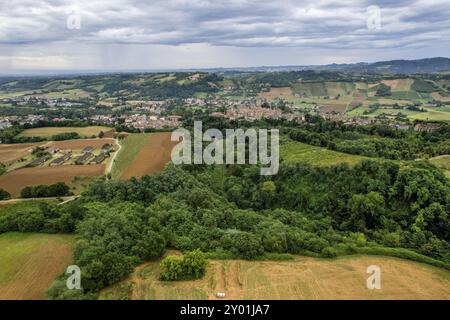 Vista aerea del paesaggio italiano che mostra lussureggianti foreste verdi e terreni agricoli sotto un cielo nuvoloso. Castell'Arquato, Valle d'Arda, PC, Italia, Europa Foto Stock