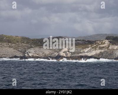 Le onde dell'Atlantico si schiantano contro la costa rocciosa norvegese Foto Stock