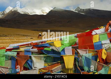 Un bellissimo paesaggio naturale di montagna dietro un tradizionale forno tibetano e una massa di bandiere di preghiera in Tibet, Cina, Asia Foto Stock