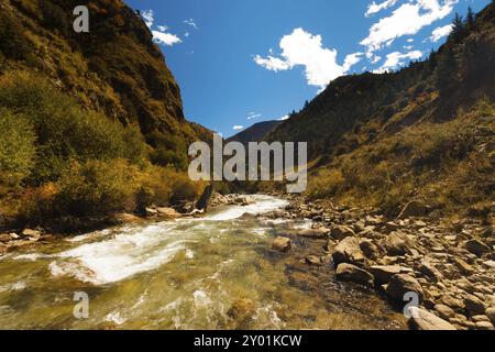 Un flusso alpino ghiacciato dall'himalaya scorre lungo la raramente vista autostrada G318, una strada che va dal Tibet orientale a Lhasa, attraverso la h Foto Stock