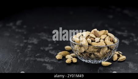 In ardesia scura con lastra tostati e salati mandorle (nel guscio) Foto Stock