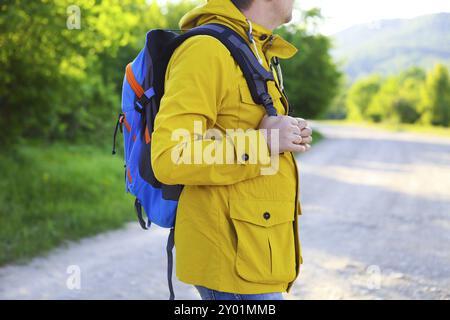 Vista laterale del giovane uomo con zaino trekking nella foresta Foto Stock