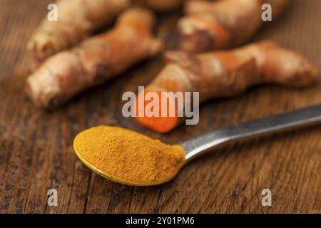 Macina la curcuma su un cucchiaio Foto Stock