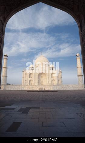Marmo bianco del Taj Mahal incorniciato attraverso la silhouette del jawab orientale grande porta con nessuno presente in un giorno di cielo blu ad Agra, India. Verticale in abbondanza Foto Stock