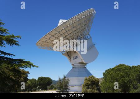 Il grande radiotelescopio dell'ESA sotto un cielo azzurro, circondato da alberi verdi, per uso scientifico, Centro europeo di Astronomia spaziale, Villafranca del CA Foto Stock