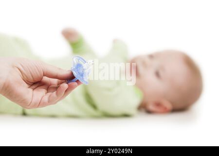 Mano madre che regala succhietto in plastica al bimbo appena nato che dorme dorme, bianco e isolato Foto Stock