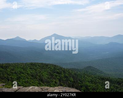 Le vedute nebbiose si estendono sulle montagne Adirondack, viste dalla tranquilla cima della Cascade Mountain, catturando la tranquilla natura selvaggia del lago Placid, N Foto Stock