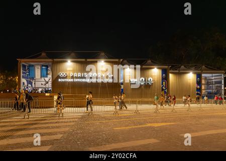 Parigi, Francia - 10 agosto 2024: Facciata laterale della Boutique ufficiale Olympic Pop-up sugli Champs-Elysees di notte Foto Stock