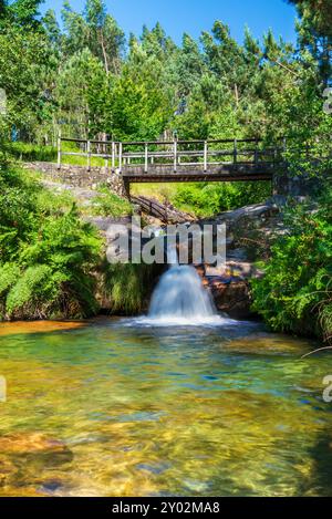 Cascata Poza de la Mora (Pozas da Moura), un piccolo bacino idrico situato sul monte Domaio con le acque del fiume Muiños, appartenente al comune Foto Stock