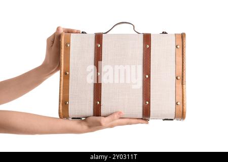 Mani femminili che reggono una valigia in legno rétro su sfondo bianco Foto Stock