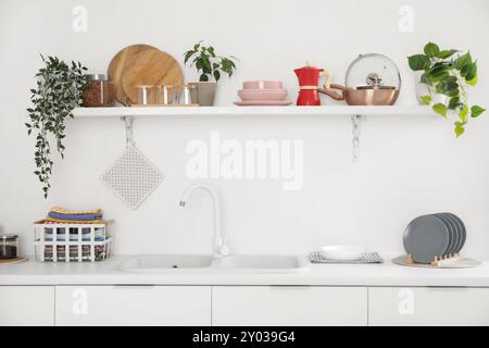 Interno di una cucina luminosa con ripiani, ripiani e utensili Foto Stock