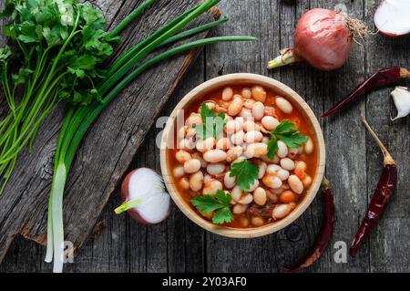 Cibo tradizionale turco, fagioli bianchi secchi con pasta di pomodoro nel piatto su sfondo di pietra scura Foto Stock