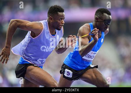 Parigi, Francia. 31 agosto 2021. Guillaume Junior Atangana (R) e la sua guida Donard Ndim Nyamjua del Refugee Paralympic Team (RPT) gareggiano durante la semifinale maschile 400m T11 di para atletica ai Giochi Paralimpici di Parigi 2024, Francia, 31 agosto 2021. Durante i Giochi Paralimpici di Parigi 2024, otto atleti e un corridore guida competono come parte della più grande squadra Paralimpica per i rifugiati di sempre. Crediti: Zhang Cheng/Xinhua/Alamy Live News Foto Stock