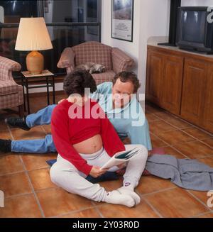 Coppia che pratica le tecniche di respirazione Lamaze a casa prima della nascita del bambino, 1994 modello rilasciato. ©Bob Daemmrich Foto Stock