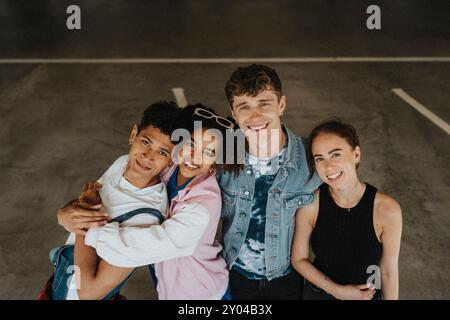 Ritratto ad angolo alto di amici allegri e femminili in piedi fianco a fianco nel parcheggio Foto Stock