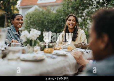 Allegra madre e figlia pranzano durante la riunione sociale alla festa in giardino Foto Stock