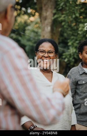 Allegra donna anziana che si diverte con un membro della famiglia nel cortile posteriore Foto Stock